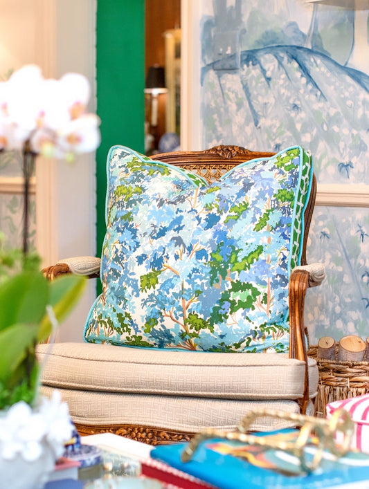 Decorative pillow on a wicker chair with a floral pattern in a home setting