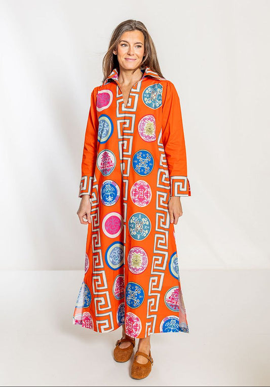 Woman wearing an orange dress with colorful geometric patterns on a white background