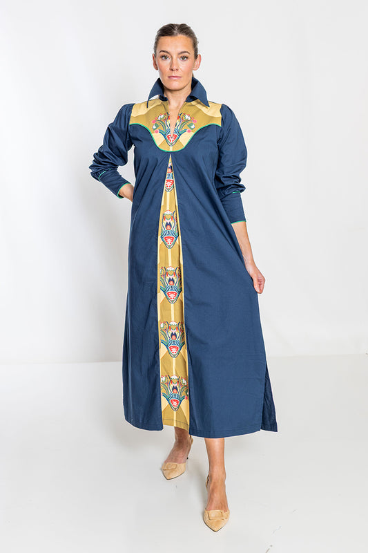 Woman wearing a long blue dress with a colorful pattern on a white background