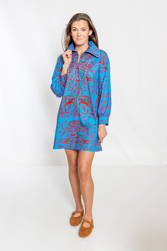 Woman wearing a blue patterned dress on a white background